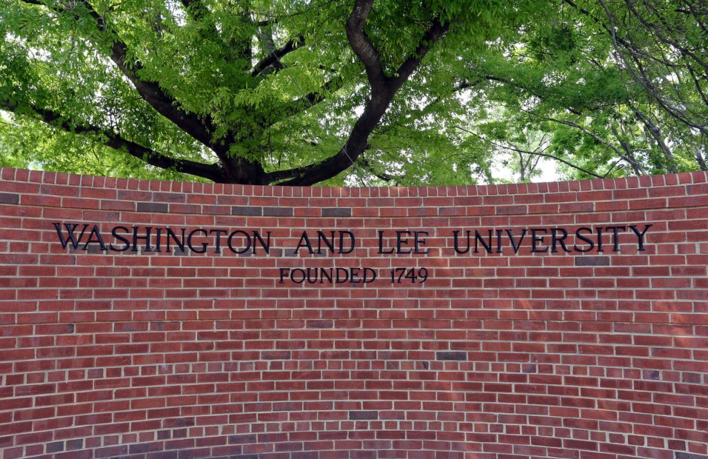 a sign in front of Washington and Lee University on a brick wall